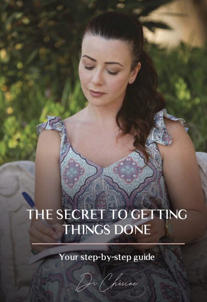 Photo of Dr. Cherine writing an e-book titled "The Secret to Getting Things Done" with passion.